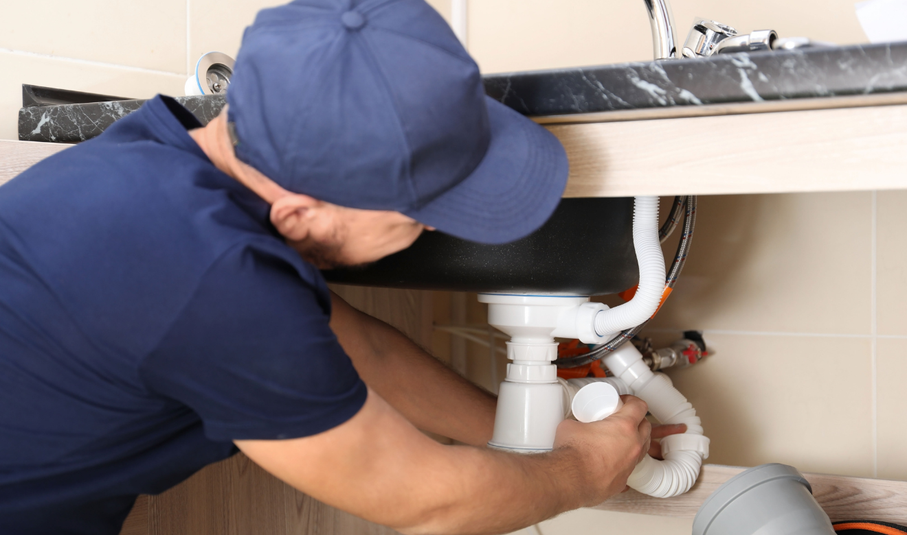 Plumber near San Diego fixing a residential kitchen pipe